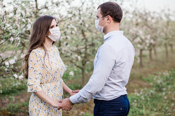 Fototapeta na wymiar lovely masked couple walks in the garden in nature