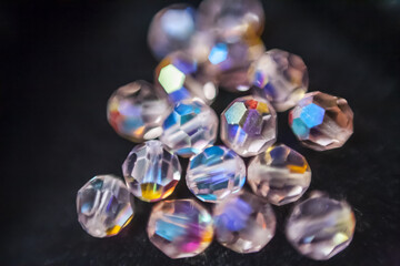 Beautiful opalescent glass beads closeup on black soft velvet background, abstract blur background
