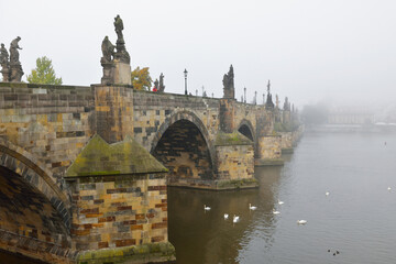 Charles Bridge, famous historic bridge that crosses Vltava river, in fog