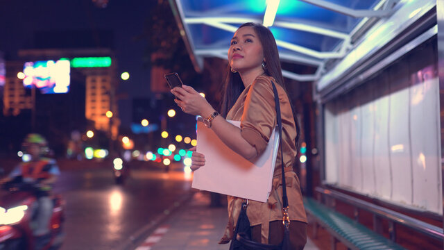 Young Asian Business Woman Calling Taxi On City Street