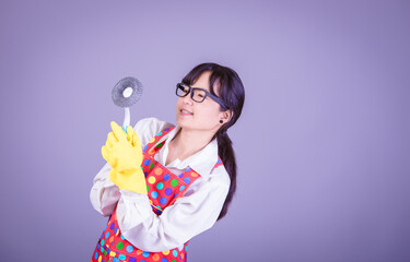 Asian Woman cleaning and polishing the kitchen worktop with a spray detergent, housekeeping and hygiene concept, accessories studio shot isolated on Gray background 