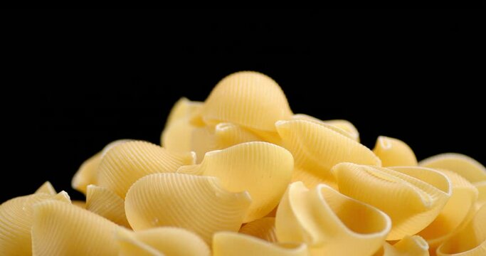 A bunch of pasta dry rigati on the table slowly rotates.