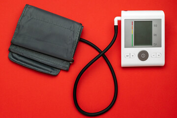 Medical instruments life. Heart hypertension check with sphygmomanometer for doctor, patient. Medical test monitor for blood pressure isolated on red background. Flat lay, top view, copy space.
