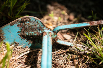 Gartenarbeit, mit blauer Gartenhacke.
