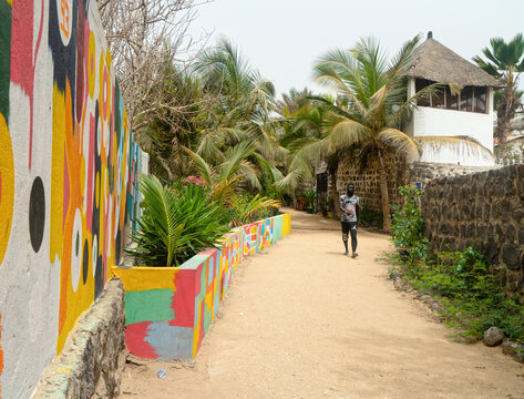 NGOR, DAKAR, SENEGAL - JUNE 6, 2020: Unidentified Senegalese man walks at the colorful street of Ngor island.