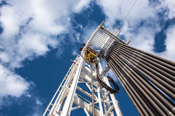 Oil rig derrick in oilfield against the bright blue sky