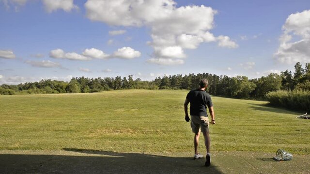 Golf player trains in a driving range completely immersed in the Tuscan countryside near Pisa, Italy