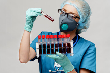 medical doctor nurse woman wearing protective mask and gloves - holding rack with virus blood tests