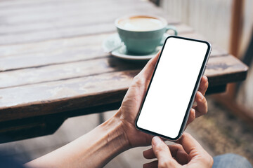 cell phone mockup image blank white screen.woman hand holding texting using mobile on desk at coffee shop.background empty space for advertise.work people contact marketing business,technology