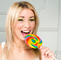 little cute blonde girl with colorful candy smiling, lifestyle people concept