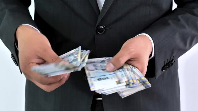 Business man in a suit counting 100 soles bills. Peruvian currency concept, counting bank notes from Peru. Executive hispanic male holding one hundred notes.