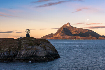 The Arctic Circle marker at 66° 33’ North on the little island of Vikingen, with the mountain of Hestmonkallen on the island of Hestmona beyond: Rødøy, Nordland, Norway