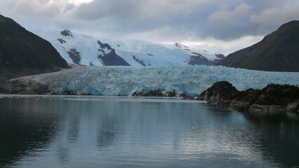 Aesthetic photography of the famous Argentine glacier, the Perito Moreno, with a unique composition and reflections of the high mountains of the Andes in the water