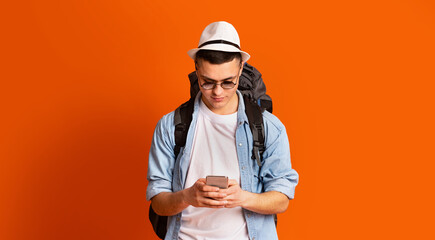 Young man backpacker using mobile phone app for travelers
