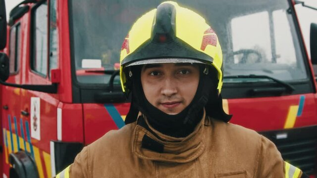 Portrait shot of the fireman in full uniform ready for the rescue. Slow motion.