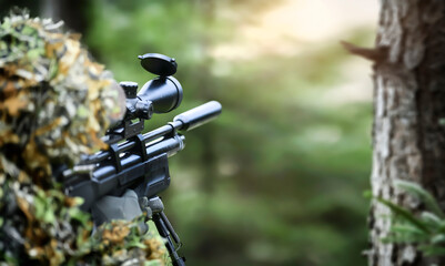 Hunter in camouflage uniform aim with gas air rifle. Soldier ifles with telescopic sight