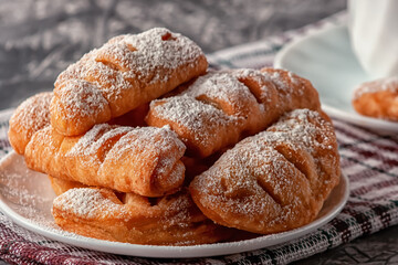 Freshly baked homemade puffs with aromatic coffee on a gray background