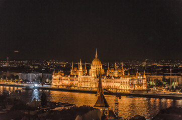 Fototapeta premium Illuminated Parliament building across river Danube in Budapest in Hungary by night