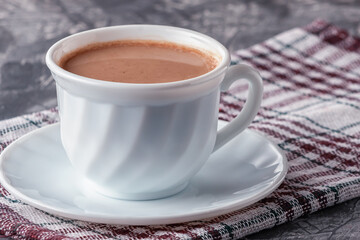 Freshly brewed aromatic coffee with cream on a gray background