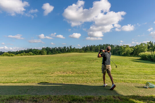 Golf player trains in a driving range completely immersed in the Tuscan countryside near Pisa, Italy