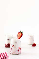 Milkshake with fresh summer strawberries, glass jars with strawberry milkshake, delicious healthy breakfast