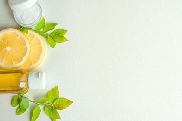 Natural set with organic butter, cream, lemon and leaves on a white background top view. Copy space