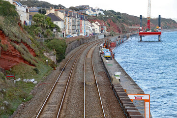 Fototapeta na wymiar Repair works on the West Coast mainline station at Dawlish in Devon following the collapse of the tracks during the storms of February 2014. A repair platform can be seen in the sea