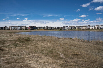 Fototapeta na wymiar Calgary, Alberta, Canada, June 01 2020: An subdivision developed up to designated habitat at the City Scape Wetlands.