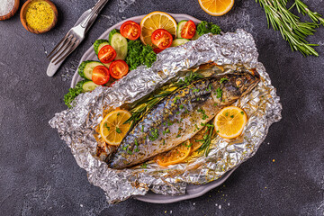 Mackerel baked in foil with vegetables on a dish