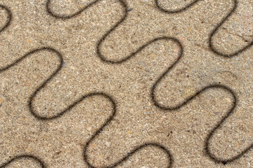 Shadows of the springs of a sun lounger on concrete