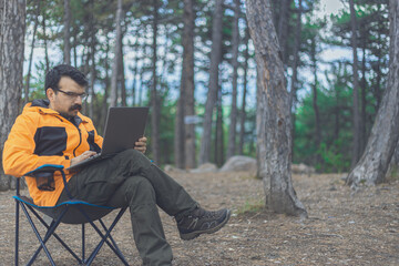 Fototapeta premium Man works with his laptop computer in jungle