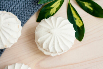 Marshmallows. Vanilla sweet homemade marshmallows. Light composition with green natural leaf and plaid. Violet flower. Sweet delicious dessert.
