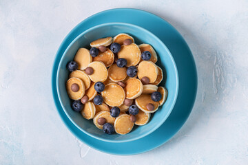 Trendy breakfast with mini pancakes, blueberries and chocolate chips.