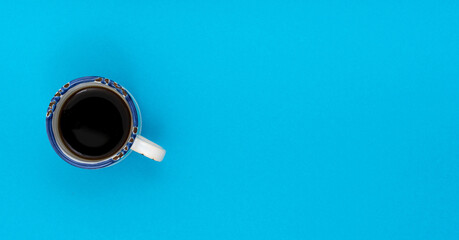 Top view, flat lay of black coffee cup on background blue.