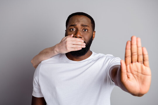 Photo of african american guy disenfranchised unfairly society shut up black race citizen pray stop bullying white skin arm close his mouth lawlessness isolated grey color background