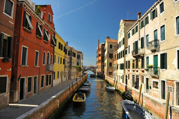 Fototapeta na wymiar Venice channels with boats, gondolas, and colorful houses and towers