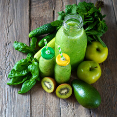 Detox juice. Summer green smoothie on the rustic wooden table. Drink made with green fruits, vegetables and greenery. Square photo.
