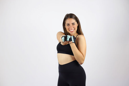Young beautiful woman standing over white isolated background wearing sport chlotes and working out