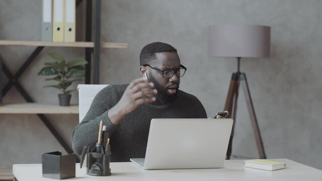 Photo of horrified scared surprised negative man who saw something terrible while browsing through his phone/laptop