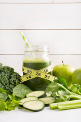Health concept. Healthy green smoothie and tape measure and ingredients on white - superfoods, detox, diet, health, vegetarian food concept surrounded by ingredients