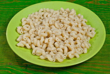 Vermicelli in a green plate on a wooden table. Food close up on an old shabby blackboard.