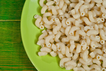 Vermicelli in a green plate on a wooden table. Food close up on an old shabby blackboard.