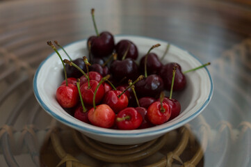 Bowl with cherries of great variety of red tones. season's fruit