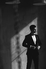 Close up of a handsome and successful man in an expensive suit. He is in a white shirt with a tie. Strong, stylish successful man in a suit posing.