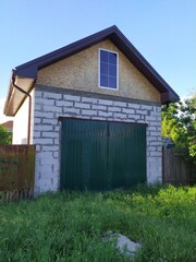 An unfinished small country house with a garage