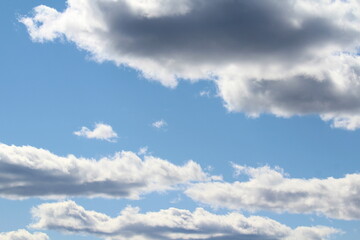White fluffy clouds on a background of blue sky in summer. The concept of weather and climate