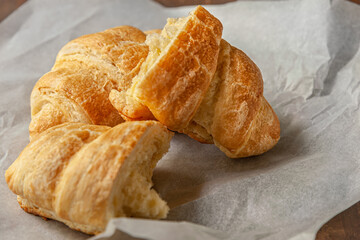 freshly baked flavorful crispy croissants on white parchment close up