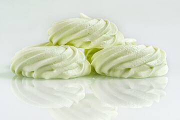 homemade pistachio meringues on a light glass surface close up