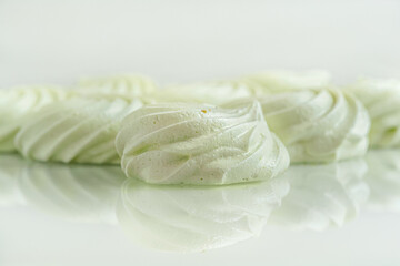 homemade pistachio meringues on a light glass surface close up