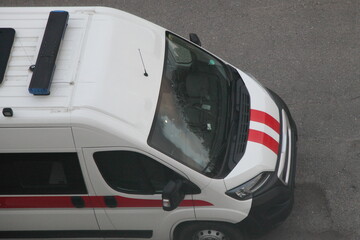 White European ambulance car mini bus top view close up with blue siren lights and red stripes